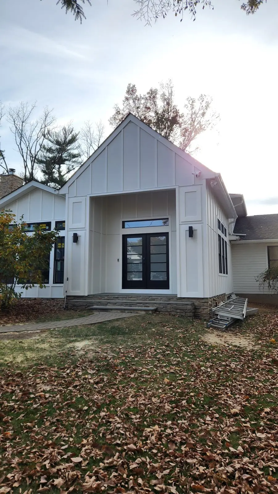 Board-and-batten gable addition with black French doors